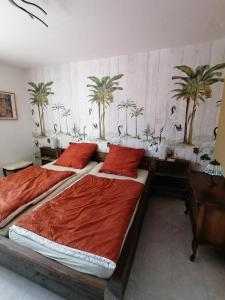 two beds in a bedroom with palm trees on the wall at Haus Sonnenkur in Heusweiler