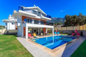 a house with a swimming pool in the backyard at Villa Sherbella in Fethiye