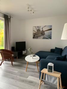 a living room with a blue couch and a table at Boddenhus Loissin in Loissin