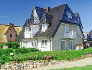 a large white house with a gambrel roof at Abaluga 4A in Wenningstedt