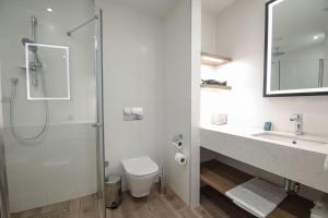 a bathroom with a shower and a toilet and a sink at Hilton Garden Inn Ankara Cankaya in Ankara +17 photos