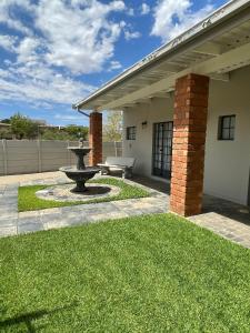 a patio with a fountain in front of a house at City comfort self catering Windhoek in Windhoek