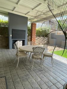 a patio with a table and chairs and a fireplace at City comfort self catering Windhoek in Windhoek