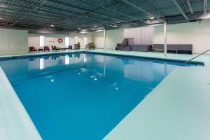 a large swimming pool with blue water at Travelodge by Wyndham Amherst in Amherst