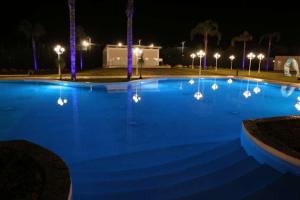 a large blue swimming pool at night with lights at Villaggio Jonio Blu in Bianco