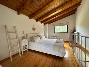 a bedroom with a white bed and a wooden floor at Μούσες in Kalavrita