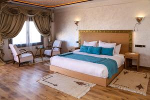 1 dormitorio con 1 cama grande con almohadas azules en Yakout Merzouga Luxury Camp en Merzouga
