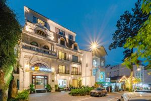 un bâtiment avec une voiture garée devant lui dans l'établissement TTR Moonstone Apart Hotel, à Đà Lạt