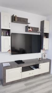 a large entertainment center with a large flat screen tv at Къща в центъра in Dobrich