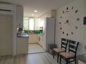 cocina con nevera, 2 sillas y mesa en Къща в центъра, en Dobrich