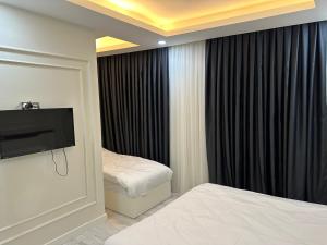 ein Hotelzimmer mit 2 Betten und einem Flachbild-TV in der Unterkunft Mitra otel in Diyarbakır