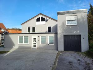 una gran casa blanca con garaje en FeWo Oda, en Bad Gandersheim