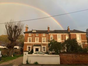 a rainbow in front of a large brick house at Top Floor. Top Notch. Tranquil Treat. Stone's throw from Thames. in Maidenhead