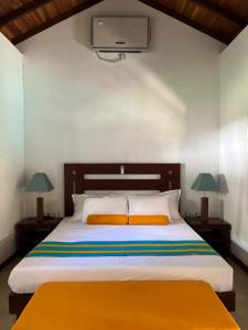 - une chambre avec un lit et une télévision murale dans l'établissement The Retreat Weligama, à Weligama
