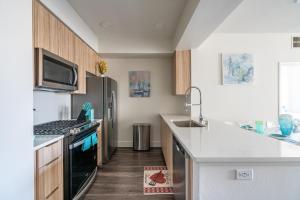 a kitchen with a sink and a stove top oven at Marina Del Rey Resort Style Apartment I Free Parking in Los Angeles