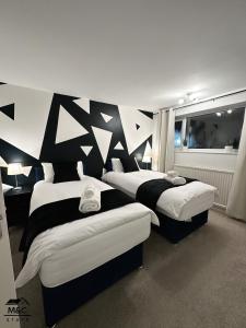 two beds in a room with black and white walls at Kettering/Stylish/ Perfect for Contractors in Kettering