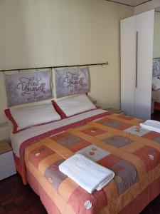 um quarto com uma cama grande com duas toalhas em Appartamento Bersani em CastellʼArquato