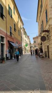 a person sitting in a chair on a city street at Casa del Surf - By Ligooria in Pietra Ligure