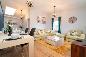 a living room with a table and a dining room at The Old Mill Cottage in Fakenham