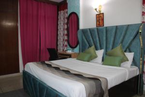 um quarto de hotel com uma cama grande e uma cabeceira em Awasthi Kozi Stays B&B - closest to VFS em Nova Deli