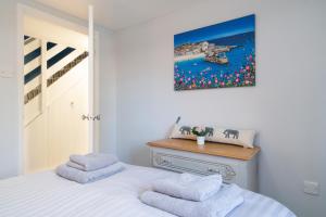 a bedroom with a bed with two towels on it at The Old Mill Cottage in Fakenham