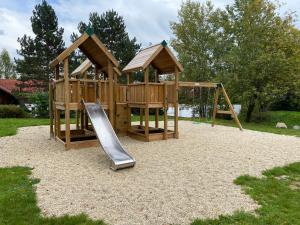 a wooden playground with a slide in a park at Ferienhaus an der Westernstadt in Eging in Eging