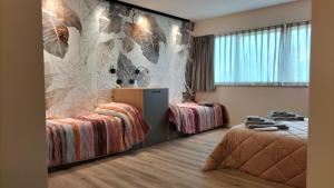 1 Schlafzimmer mit 2 Betten und Wandbild in der Unterkunft fragilerooms in Dolo