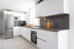 kuchnia z białymi szafkami i urządzeniami ze stali nierdzewnej w obiekcie Penthouse Lord of Mijas , Sea View 6P, Casa Banderas, D23A w mieście La Cala de Mijas +37 zdjęć