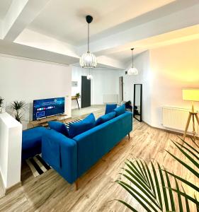 uma sala de estar com um sofá azul e uma televisão em Tree House em Bucareste
