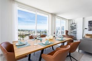jadalnia ze stołem i krzesłami oraz dużymi oknami w obiekcie Penthouse Lord of Mijas , Sea View 6P, Casa Banderas, D23A w mieście La Cala de Mijas