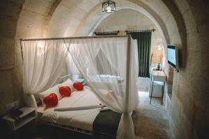 a bedroom with a bed with red pillows at DAPHNE CAVE HOTEL in Avanos