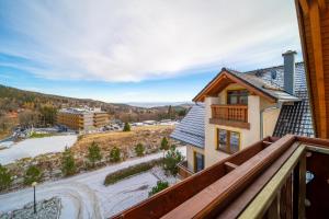 a view from the balcony of a house with a snow covered yard at Trevilles Apartamenty Mountain View in Szklarska Poręba