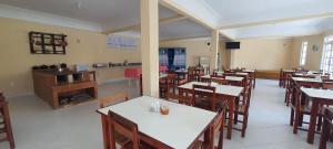 a restaurant with tables and chairs and a counter at Pousada Pau Brasil in Guapimirim