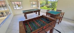 a room with two ping pong tables and a pool table at Pousada Pau Brasil in Guapimirim