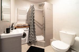 a bathroom with a toilet and a sink and a washing machine at Trevilles Apartamenty Mountain View in Szklarska Poręba +5 photos