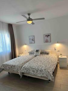 een slaapkamer met een bed en een plafondventilator bij Pachi Beach Alisios Playa Corralejo in Corralejo