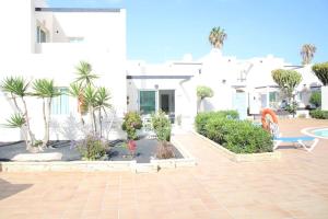een huis met een binnenplaats met bomen en planten bij Pachi Beach Alisios Playa Corralejo in Corralejo