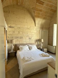 a bedroom with a large white bed with two lamps at LuLeccio in Lecce
