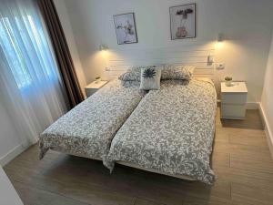 een slaapkamer met een groot bed en 2 nachtkastjes bij Pachi Beach Alisios Playa Corralejo in Corralejo