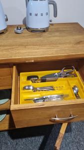 un cajón amarillo con un montón de utensilios. en Fair Oak Self-Catering Accomodation, en Sandown