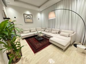 un soggiorno con divano bianco e tavolo di شقق عبية الفندقية a Riyad
