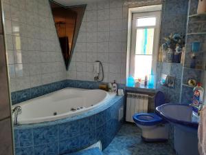a bathroom with a tub and a toilet and a sink at PENSJONAT KAPRYS in Jesionka +93 photos