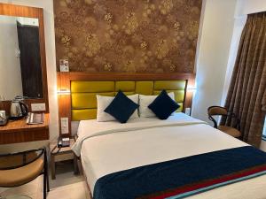 1 dormitorio con 1 cama grande con almohadas azules en SriKrishna Paradise Hotel Thane Navi Mumbai, en Thane