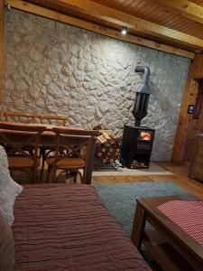 a room with a fireplace and a table and chairs at Chalet Hill Zabljak in Žabljak