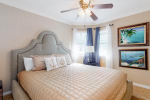 a bedroom with a large bed with a ceiling fan at Seascape Gem in Galveston