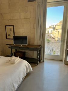 um quarto com uma cama, uma secretária e uma janela em LuLeccio em Lecce