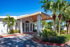 una casa con palmeras delante en Paradise Island Beach Club Ocean View Villas en Creek Village