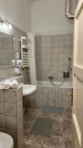 a bathroom with a tub and a sink and a toilet at Central Hotel 21 and Apartments in Budapest