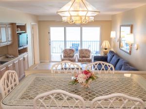 een keuken en een woonkamer met een tafel en stoelen bij Paradise Island Beach Club Ocean View Villas in Creek Village