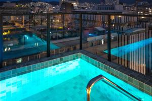 a swimming pool on the roof of a building at night at Life Residence in Belo Horizonte